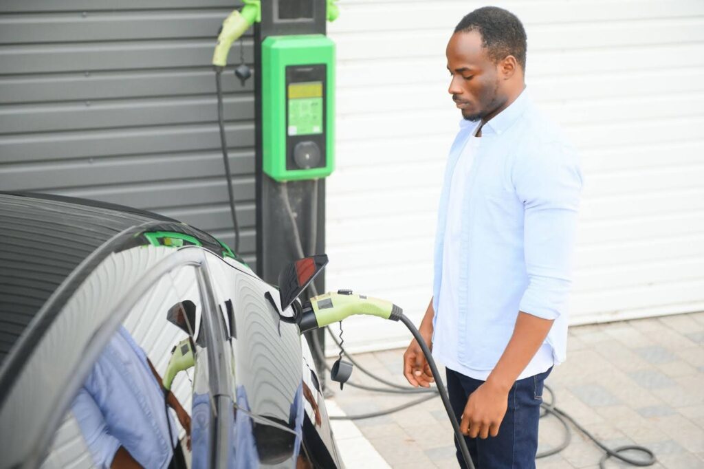 Man charging an electric car at a public EV station.